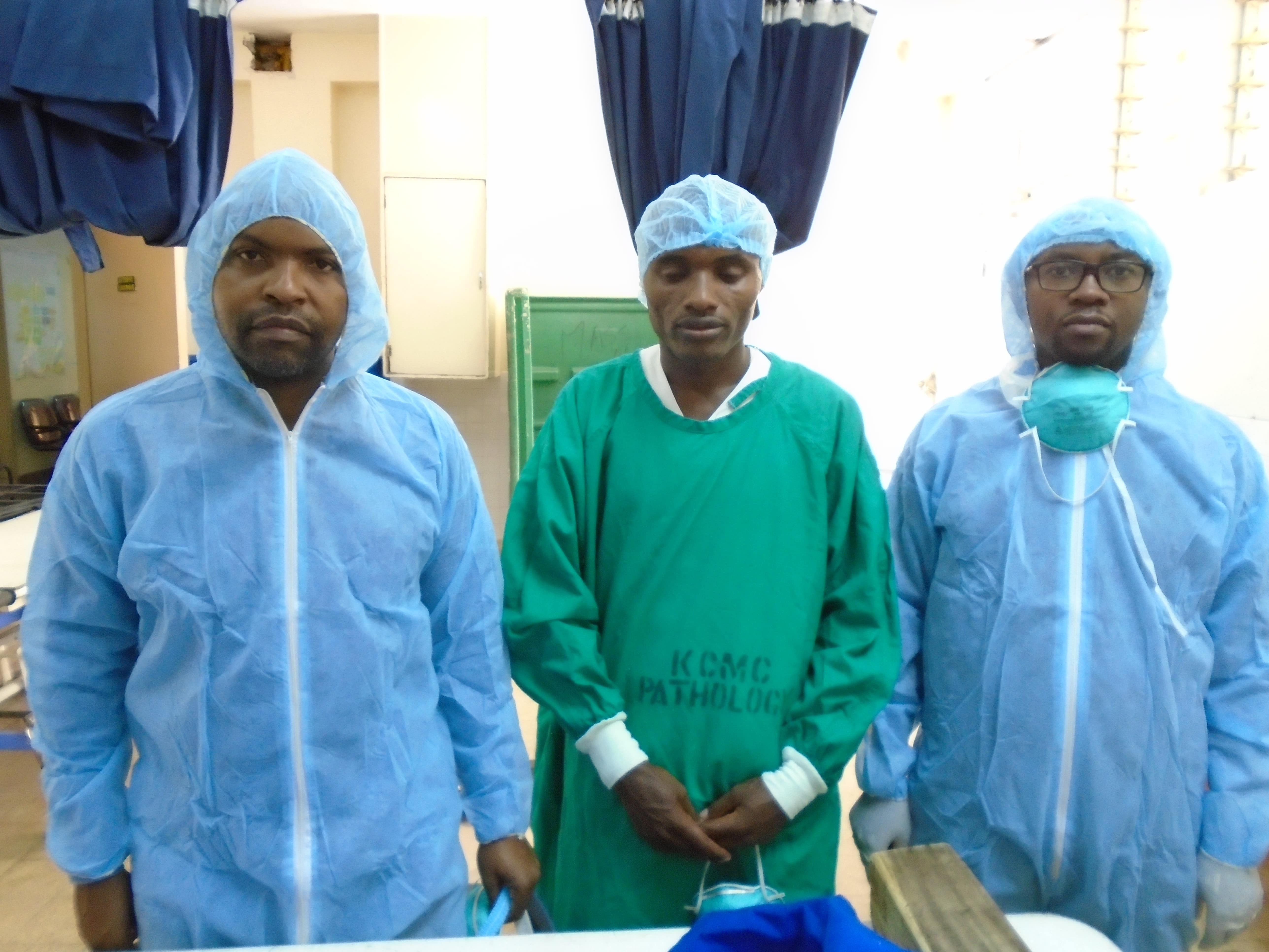 Three people wearing personal protective equipment